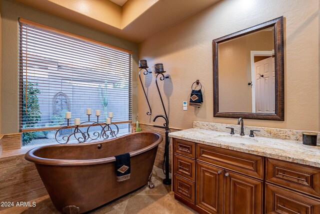 bathroom with vanity, a washtub, and tile patterned floors