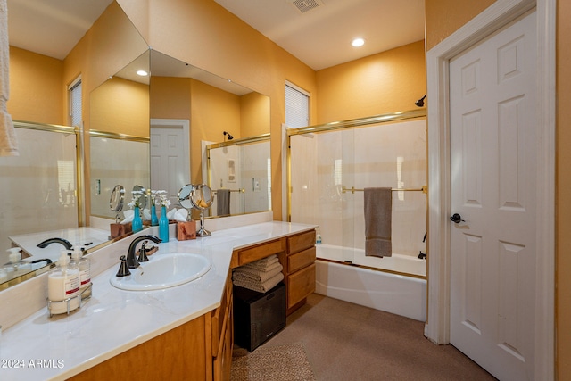 bathroom featuring enclosed tub / shower combo and vanity