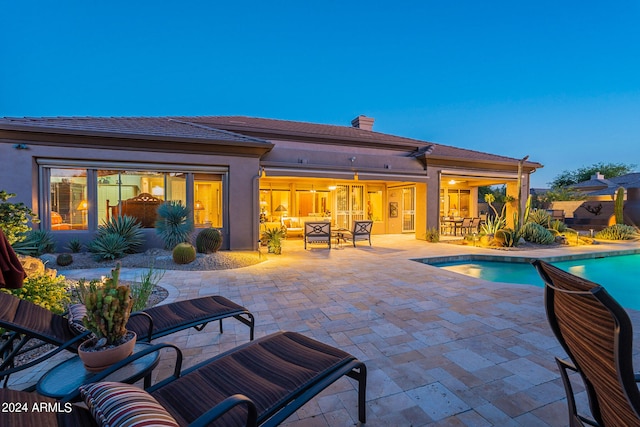 pool at dusk with a patio area