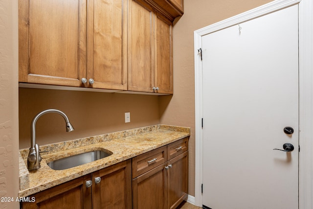 interior space with light stone counters and sink