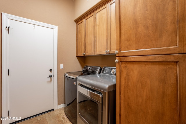 washroom featuring washing machine and clothes dryer and cabinets