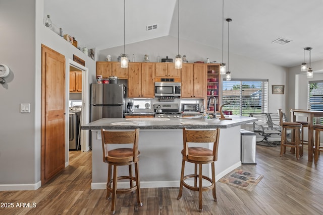 17696 W Foothill Rd, Yarnell, AZ 85362 - kitchen with appliances with stainless steel finishes, wood finished floors, dark countertops, washer / dryer, and high vaulted ceiling