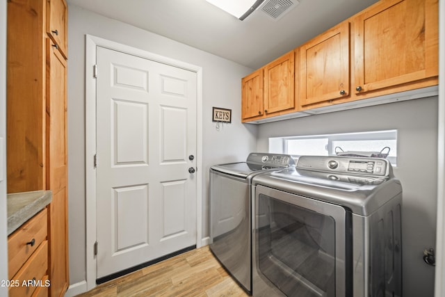 17696 W Foothill Rd, Yarnell, AZ 85362 - laundry area featuring washing machine and clothes dryer, light wood-style flooring, and cabinet space
