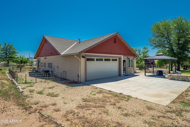 17696 W Foothill Rd, Yarnell, AZ 85362 - view of side of home with a gazebo, an attached garage, driveway, a patio, and stucco siding