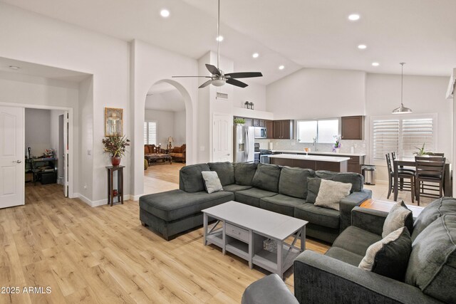 21335 N 64th Ave, Glendale, AZ 85308 - living room with high vaulted ceiling, light wood-style flooring, arched walkways, a ceiling fan, and recessed lighting