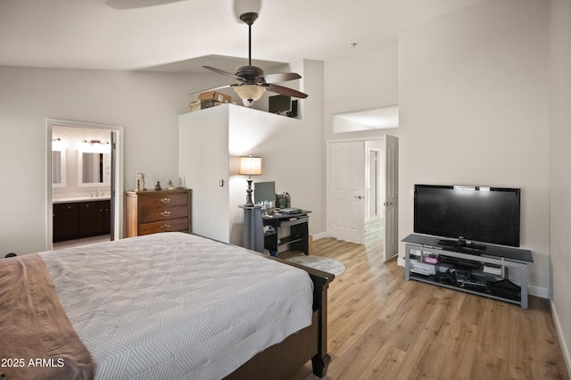 21335 N 64th Ave, Glendale, AZ 85308 - bedroom with high vaulted ceiling, light wood-style floors, baseboards, and connected bathroom