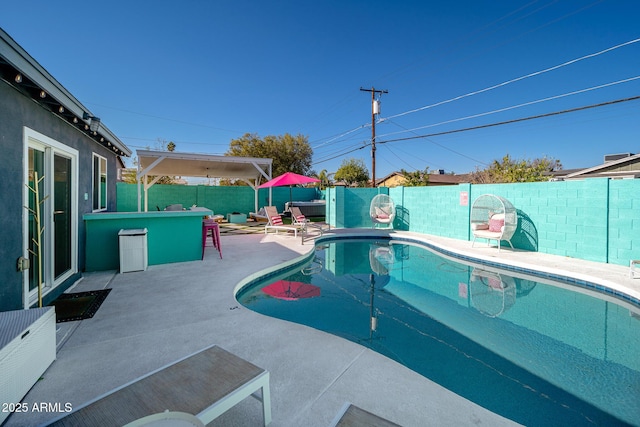 view of pool with a bar and a patio area