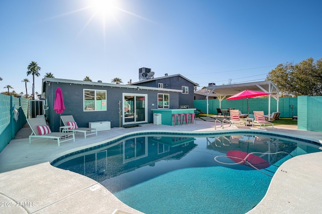 view of swimming pool featuring an outdoor bar, a patio area, and central air condition unit