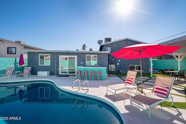 view of pool with a patio and exterior bar