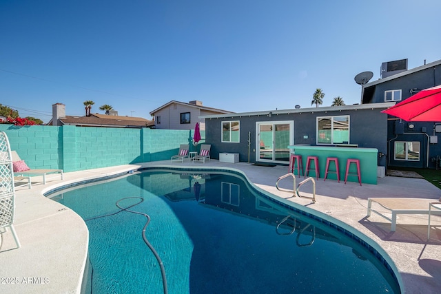 view of pool featuring a bar and a patio