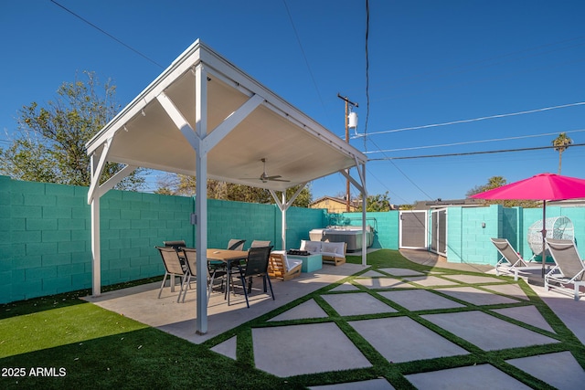 view of patio / terrace featuring ceiling fan, a hot tub, and an outdoor living space