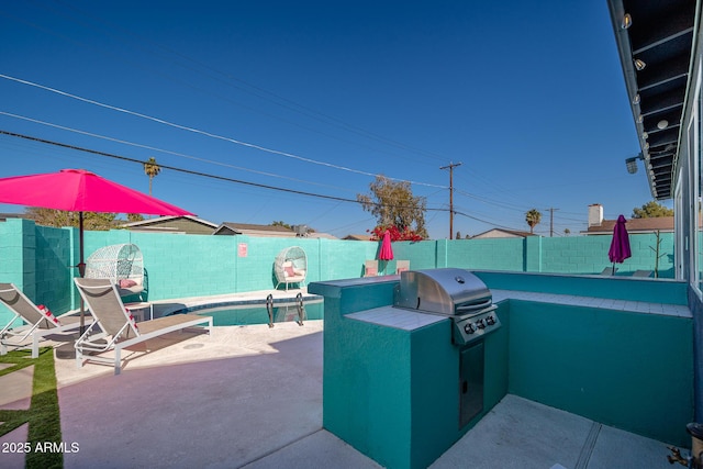 view of patio / terrace with a swimming pool, grilling area, and area for grilling