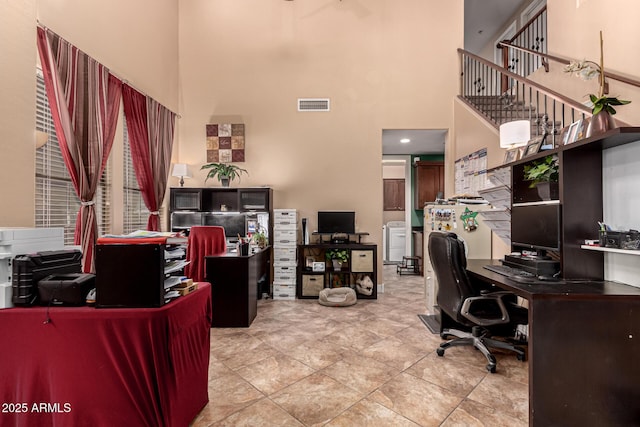 office space with a towering ceiling and tile patterned floors