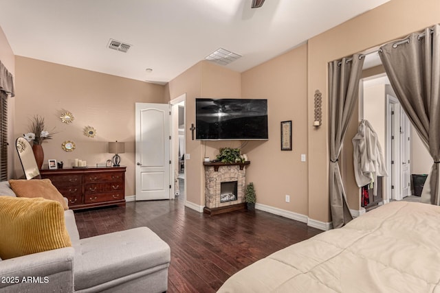 bedroom featuring dark wood-type flooring and a fireplace