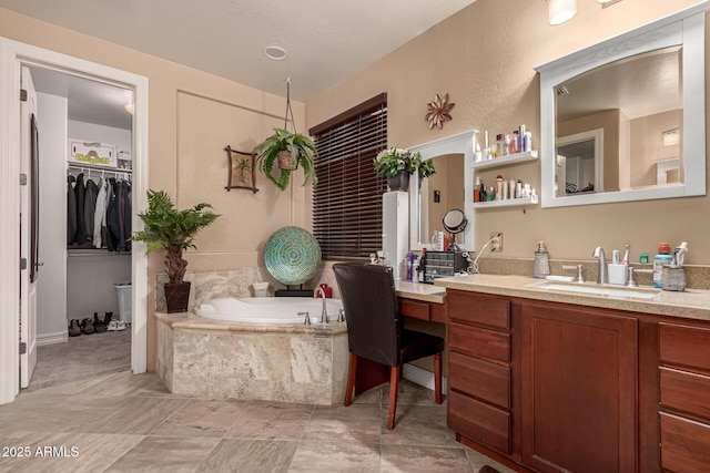 bathroom with a relaxing tiled tub and vanity