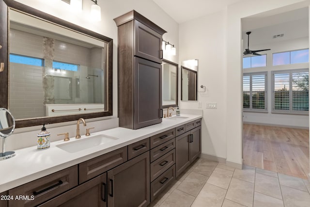 bathroom with hardwood / wood-style floors, ceiling fan, tiled shower, and vanity