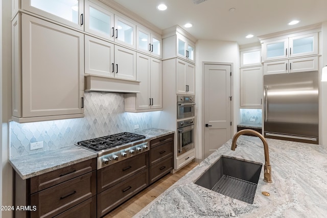 kitchen featuring dark brown cabinets, white cabinetry, sink, and appliances with stainless steel finishes