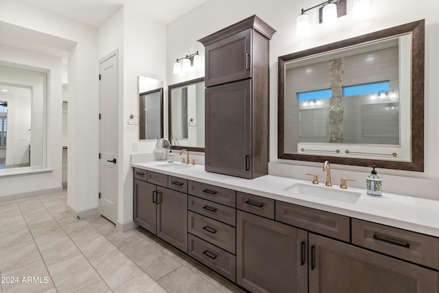 bathroom with tiled shower, vanity, and tile patterned floors