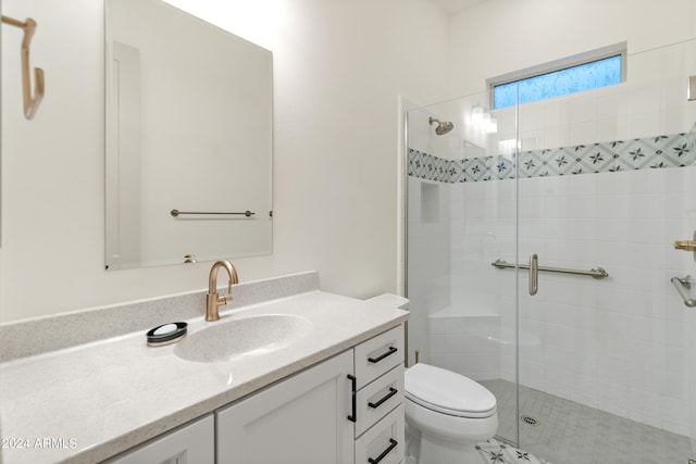 bathroom featuring vanity, a shower with shower door, and toilet