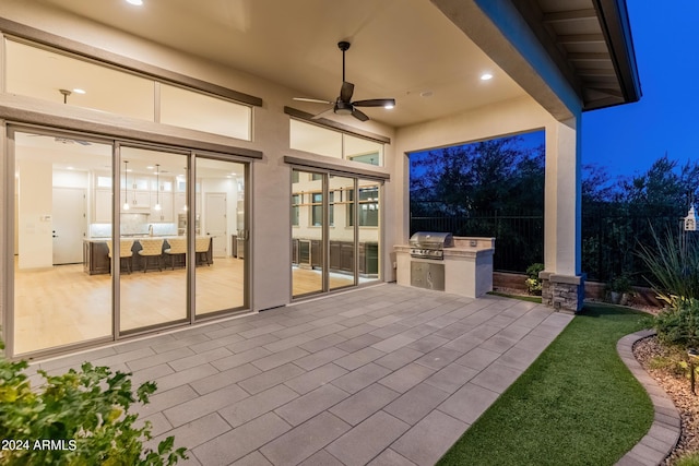 view of patio / terrace with area for grilling, ceiling fan, and a grill