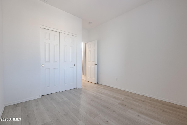 unfurnished bedroom featuring a closet and light hardwood / wood-style flooring