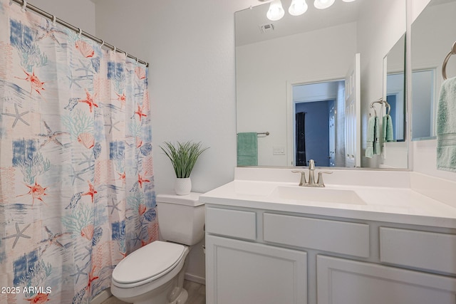 bathroom featuring curtained shower, vanity, and toilet