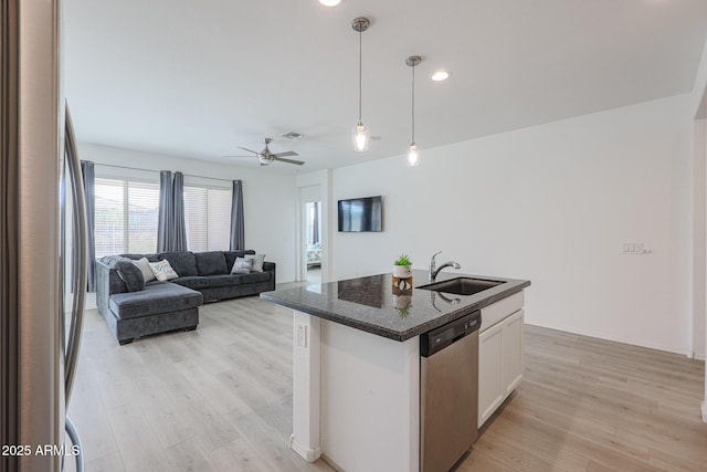 kitchen with pendant lighting, white cabinets, sink, an island with sink, and stainless steel appliances