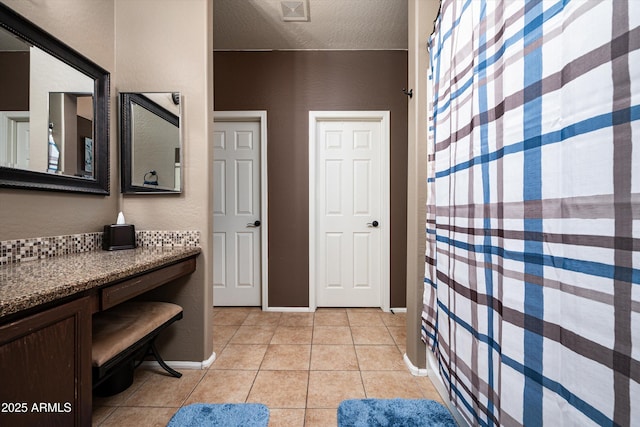 bathroom featuring a textured ceiling, tile patterned floors, and vanity