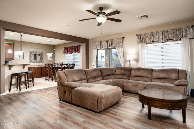 living room with ceiling fan and light hardwood / wood-style flooring