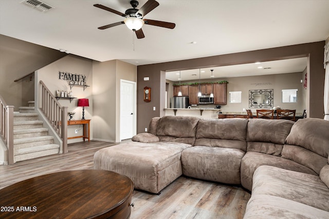 living room with ceiling fan and light hardwood / wood-style floors