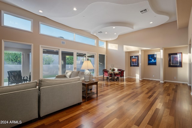 living room featuring hardwood / wood-style floors and a towering ceiling