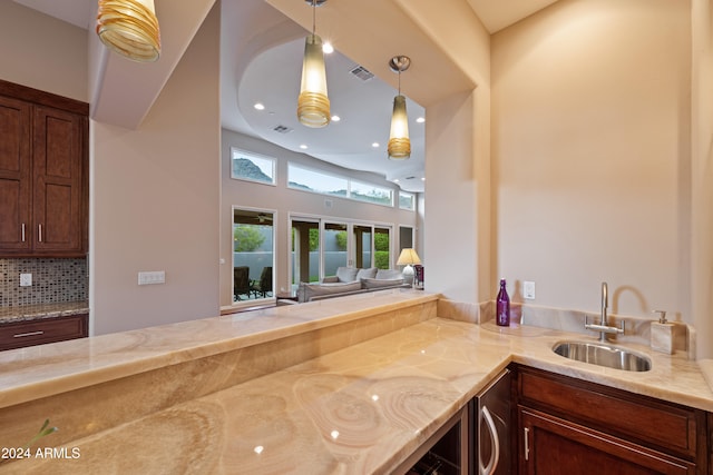 kitchen featuring backsplash, sink, and hanging light fixtures