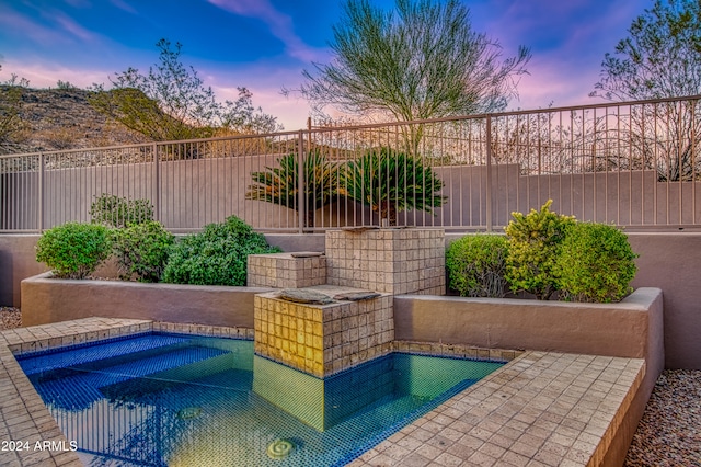 pool at dusk with a jacuzzi