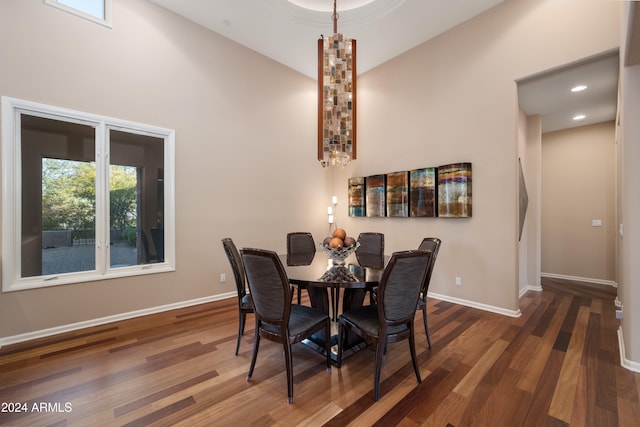 dining area featuring high vaulted ceiling and dark wood-type flooring