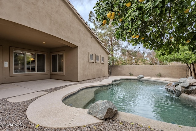 view of swimming pool with pool water feature and a patio