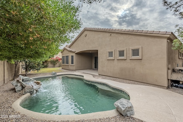 view of swimming pool with pool water feature and a patio area