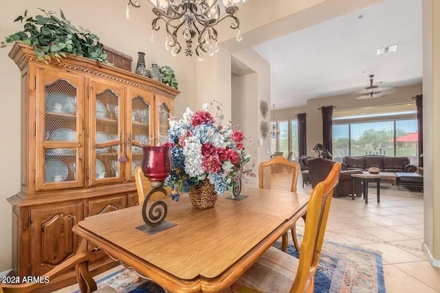 tiled dining area with ceiling fan with notable chandelier