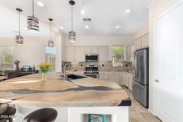 kitchen featuring pendant lighting, plenty of natural light, sink, and stainless steel appliances