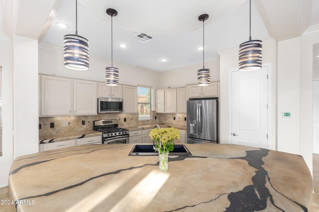 kitchen featuring decorative backsplash, ornamental molding, stainless steel appliances, sink, and pendant lighting