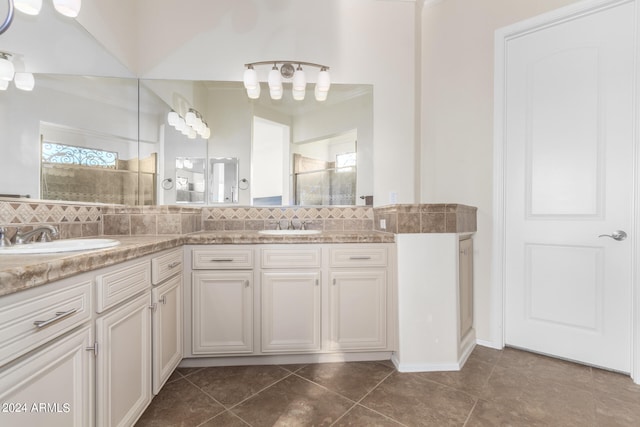 bathroom featuring decorative backsplash, vanity, tile patterned floors, and a shower with door