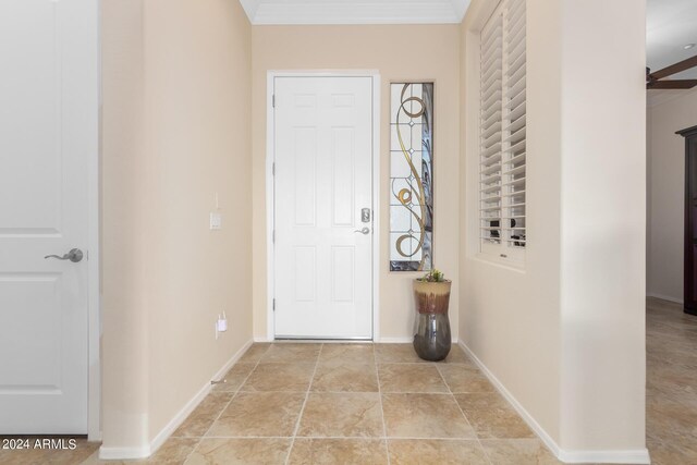 entrance foyer with ceiling fan and ornamental molding