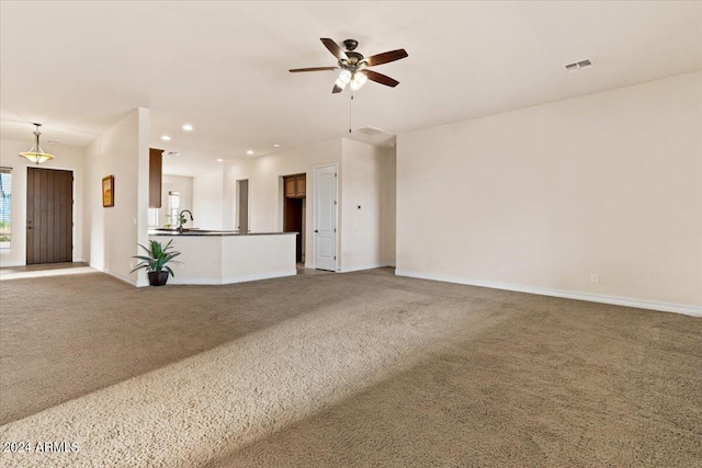 unfurnished living room with carpet flooring and ceiling fan