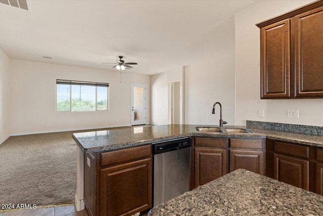 kitchen with ceiling fan, sink, stainless steel dishwasher, dark stone counters, and light carpet