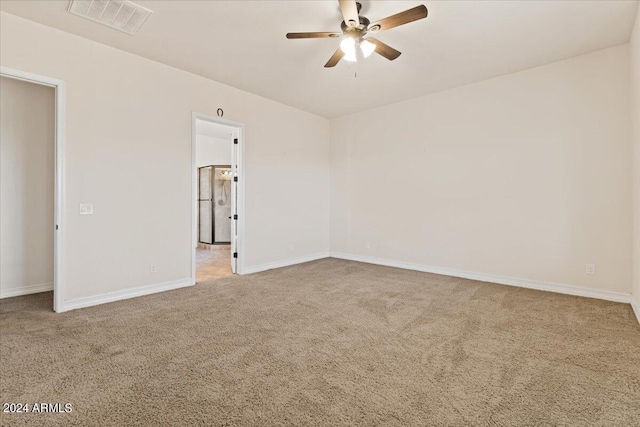 carpeted spare room with ceiling fan