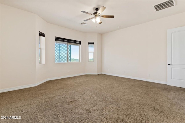 carpeted spare room featuring ceiling fan