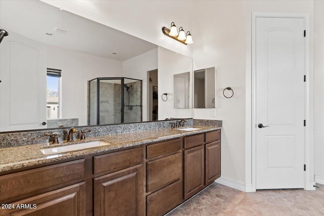 bathroom featuring tile patterned flooring, vanity, and a shower with door