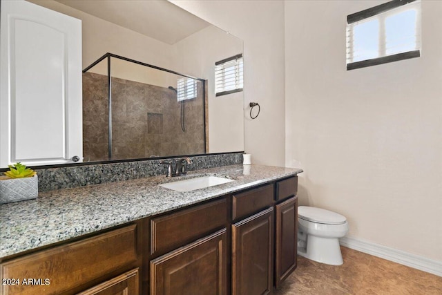 bathroom with tile patterned flooring, vanity, toilet, and a tile shower