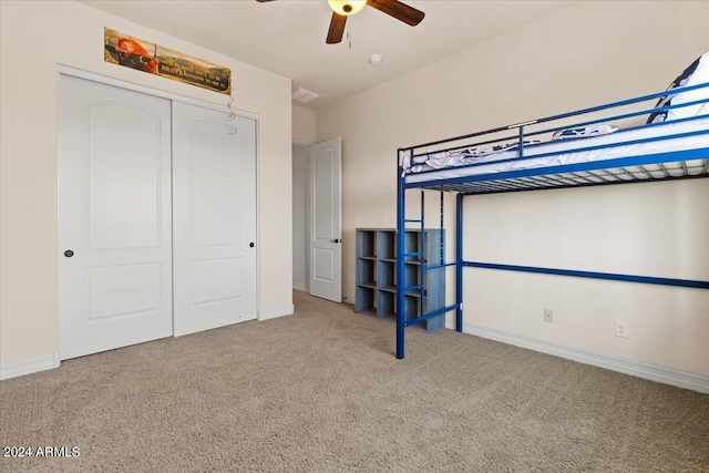 unfurnished bedroom with ceiling fan, a closet, and carpet floors