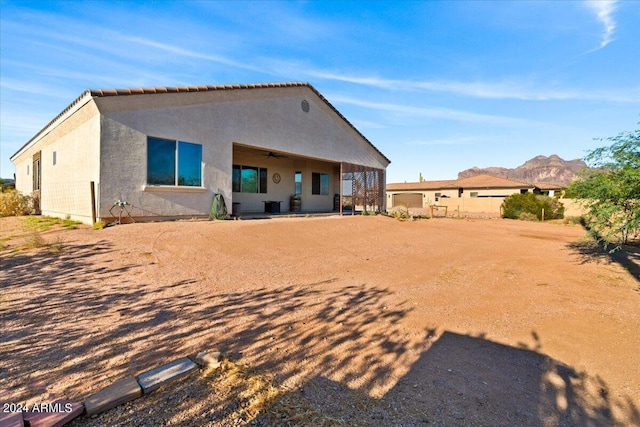 back of property featuring a mountain view and ceiling fan