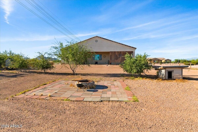 view of yard featuring a patio, a fire pit, and a storage shed